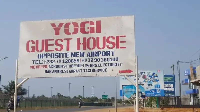 Yogi Guest House signboard — opposite New Airport Gate
